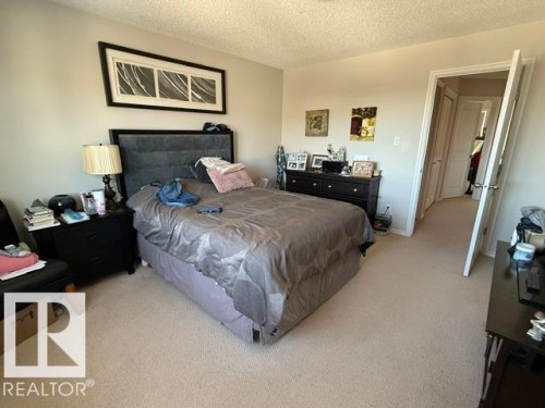 The property features a carpeted room with light-colored walls and a textured ceiling - 21316 95 Avenue, Edmonton, AB - Indoor Photo Showing Bedroom