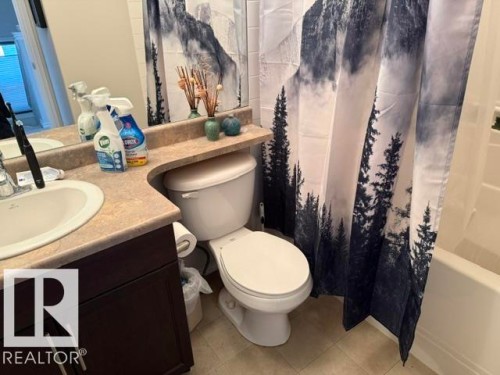 This bathroom features a vanity with a countertop and an integrated sink, a toilet, and a shower-tub combination - 21316 95 Avenue, Edmonton, AB - Indoor Photo Showing Bathroom