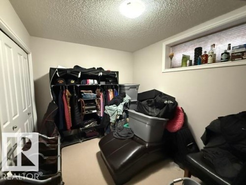 This room features a window with blinds, a ceiling-mounted light fixture, and a white paneled door - 21316 95 Avenue, Edmonton, AB - Indoor Photo Showing Other Room