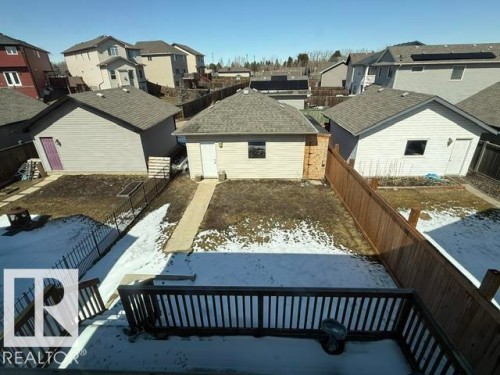 The property features a fenced yard, a detached garage with a side entry door and a window, and a concrete pathway leading to the garage - 21316 95 Avenue, Edmonton, AB - Outdoor