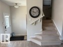 The property features a front entrance with a white door, a light fixture, and a staircase with carpeted steps and a white handrail - 21316 95 Avenue, Edmonton, AB  - Indoor Photo Showing Other Room 