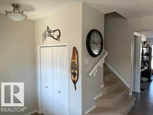 This inviting interior features light-colored walls and a carpeted staircase with a white handrail - 21316 95 Avenue, Edmonton, AB - Indoor Photo Showing Other Room