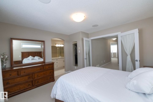 The property features a bedroom with neutral-toned walls and carpeted flooring - 132 Kirpatrick Way, Leduc, AB - Indoor Photo Showing Bedroom