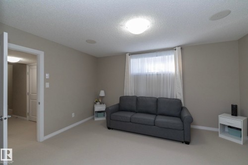 Living space featuring neutral colored walls, carpeting, and a window with white blinds and curtains - 132 Kirpatrick Way, Leduc, AB - Indoor