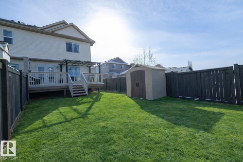Extensive yard with a well-maintained lawn, privacy fencing, and a storage shed - 132 Kirpatrick Way, Leduc, AB - Outdoor With Deck Patio Veranda