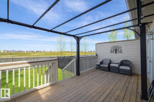 The property features a spacious wooden deck with a metal pergola structure, offering an inviting outdoor area - 132 Kirpatrick Way, Leduc, AB - Outdoor With Deck Patio Veranda With Exterior