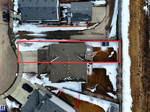Aerial view of the property, showcasing the roofline, driveway, and backyard space - 132 Kirpatrick Way, Leduc, AB - 