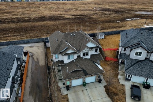 The property features a multi-level design with a double garage and a paved driveway - 132 Kirpatrick Way, Leduc, AB - Outdoor