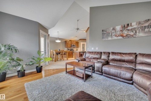 The living area features hardwood floors and vaulted ceilings - 316 Avena Link, Leduc, AB - Indoor Photo Showing Living Room
