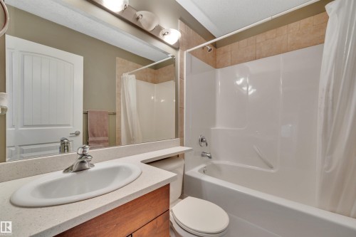 The bathroom features a vanity with a white countertop and an integrated sink, a toilet, and a bathtub with a shower - 316 Avena Link, Leduc, AB - Indoor Photo Showing Bathroom