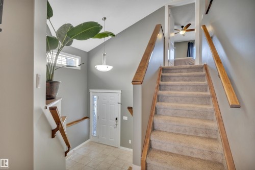 The entry features a white paneled door with a frosted glass insert, a tiled floor, and a vaulted ceiling with a hanging light fixture - 316 Avena Link, Leduc, AB - Indoor Photo Showing Other Room