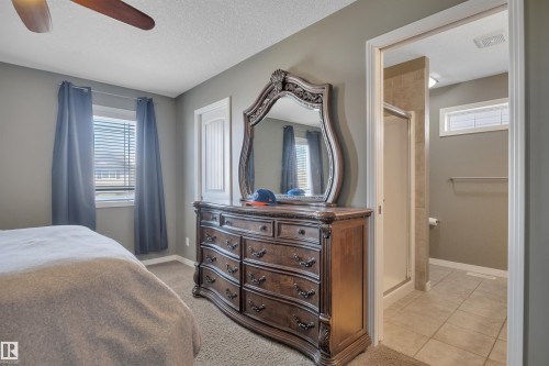 This bedroom features carpeted flooring, a window with blinds and drapes, and a ceiling fan - 316 Avena Link, Leduc, AB - Indoor Photo Showing Bedroom