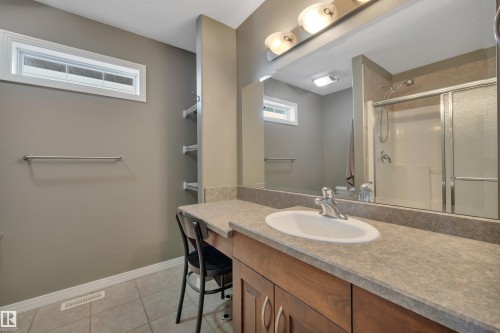 Bathroom featuring a vanity with a single basin sink, a large mirror, and overhead lighting - 316 Avena Link, Leduc, AB - Indoor Photo Showing Bathroom
