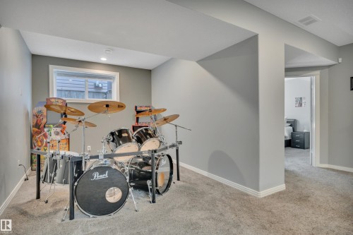 This versatile room features neutral grey walls, a window providing natural light, and plush grey carpeting - 316 Avena Link, Leduc, AB - Indoor