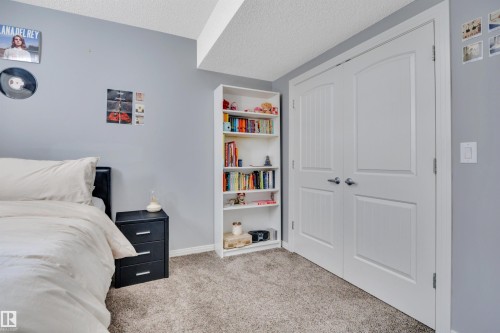 Bedroom featuring light gray walls, plush gray carpeting, and a built-in white bookshelf - 316 Avena Link, Leduc, AB - Indoor Photo Showing Bedroom