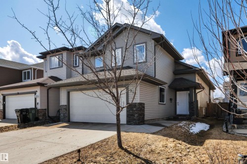 The property features a two-story structure with light-colored siding and a dark roof - 316 Avena Link, Leduc, AB - Outdoor With Facade