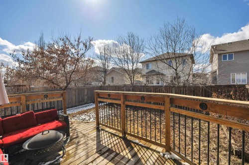 The property features a spacious wooden deck, complete with a dark wooden railing with black spindles - 316 Avena Link, Leduc, AB - Outdoor With Deck Patio Veranda