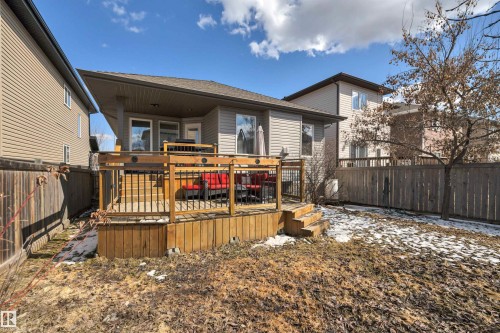 The property features a wooden deck with black railings, accessible via exterior stairs - 316 Avena Link, Leduc, AB - Outdoor With Deck Patio Veranda