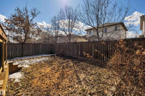 The property features a fenced yard, a wooden deck, and mature trees - 316 Avena Link, Leduc, AB - Outdoor