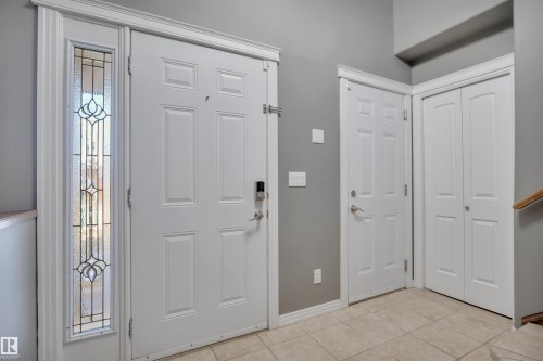 Entryway featuring a decorative glass sidelight, tile flooring, and white paneled doors - 316 Avena Link, Leduc, AB - Indoor Photo Showing Other Room