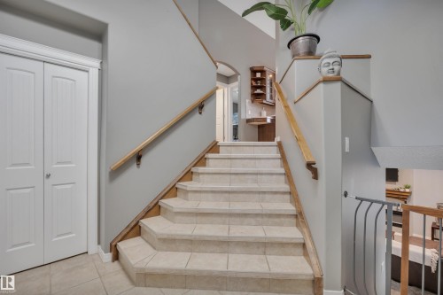 The property features a staircase with tile steps, light gray walls, and a wooden handrail - 316 Avena Link, Leduc, AB - Indoor Photo Showing Other Room