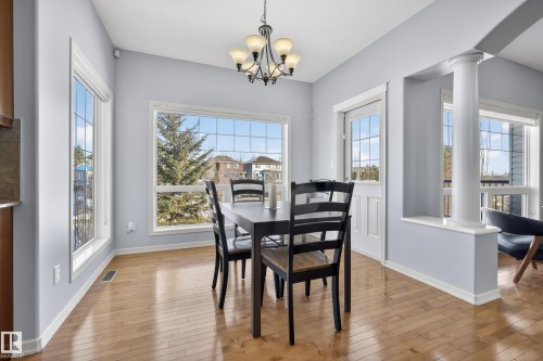 This dining area features hardwood floors and expansive windows, allowing for abundant natural light - 20714 56A Avenue, Edmonton, AB - Indoor Photo Showing Dining Room
