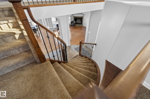 The property features a staircase with carpeted steps and a wooden handrail with wrought iron balusters - 20714 56A Avenue, Edmonton, AB - Indoor Photo Showing Other Room