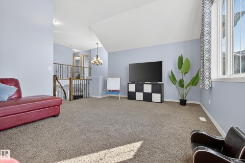 Spacious room featuring carpeted flooring, vaulted ceilings, and a large window providing natural light - 20714 56A Avenue, Edmonton, AB - Indoor Photo Showing Other Room