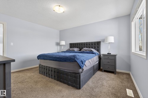 Bedroom with light blue walls, brown carpet, and a window providing natural light - 20714 56A Avenue, Edmonton, AB - Indoor Photo Showing Bedroom