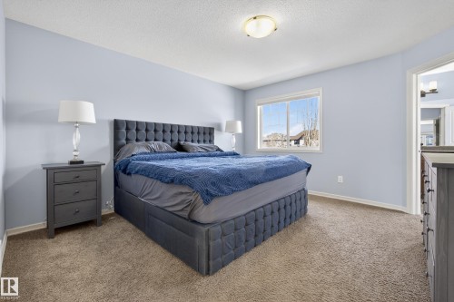Bedroom featuring light blue walls, brown carpet, and a window providing natural light - 20714 56A Avenue, Edmonton, AB - Indoor Photo Showing Bedroom
