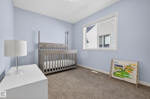 This room features light blue walls, a window providing natural light, and carpeted flooring - 20714 56A Avenue, Edmonton, AB - Indoor Photo Showing Bedroom
