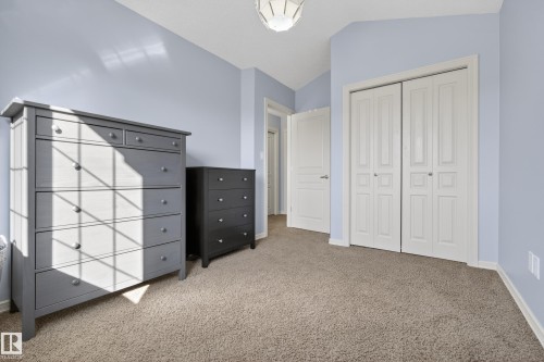 This property features soft blue walls, a light brown carpet, and a bi-fold closet with white paneled doors - 20714 56A Avenue, Edmonton, AB - Indoor