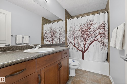 Bathroom featuring a vanity with a white oval sink and chrome faucet, a shower/tub combination, and tiled flooring - 20714 56A Avenue, Edmonton, AB - Indoor Photo Showing Bathroom