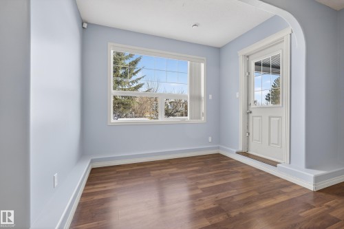 This room features wood-style flooring, light blue walls, and white trim - 20714 56A Avenue, Edmonton, AB - Indoor Photo Showing Other Room