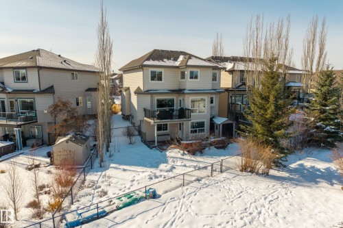 The property features a two-story exterior with balconies and a fenced yard - 20714 56A Avenue, Edmonton, AB - Outdoor