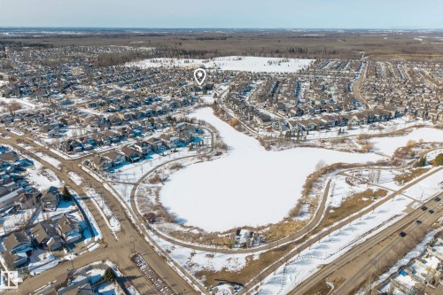 Aerial view of the surrounding neighborhood, featuring a frozen body of water and winding roads - 20714 56A Avenue, Edmonton, AB - Outdoor With View