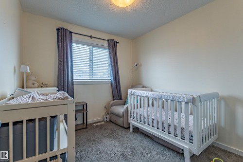 This room features light-colored walls, a window with blinds and dark curtains, and a ceiling light fixture - 2679 Maple Way, Edmonton, AB - Indoor Photo Showing Bedroom