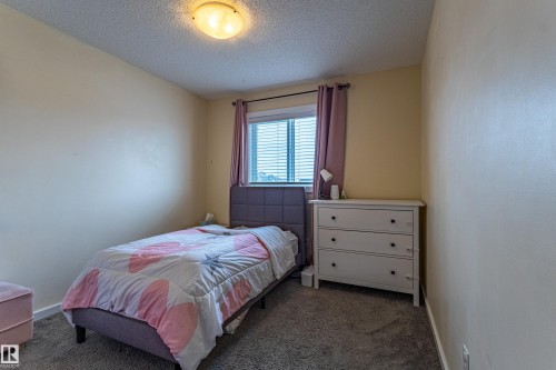 This room features a window with blinds, carpeted flooring, and a ceiling light fixture - 2679 Maple Way, Edmonton, AB - Indoor Photo Showing Bedroom