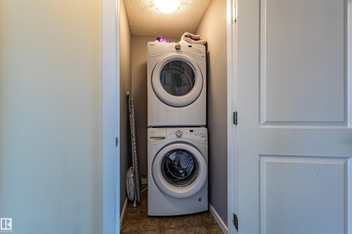Dedicated laundry area featuring a stacked washer and dryer, along with tiled flooring - 2679 Maple Way, Edmonton, AB - Indoor Photo Showing Laundry Room