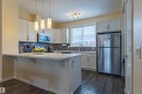 The kitchen features white cabinetry, a stainless steel refrigerator, and a built-in microwave - 2679 Maple Way, Edmonton, AB  - Indoor Photo Showing Kitchen With Upgraded Kitchen 