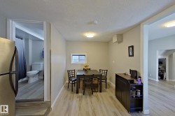 Dining area with light-colored walls, a dark dining table with chairs, and light wood-style flooring - 
