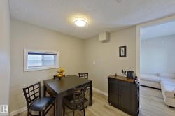 This dining area features light-colored walls and a window with blinds, providing natural light - 