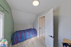 This room features light-colored flooring, a window, and a door with dark hardware - 