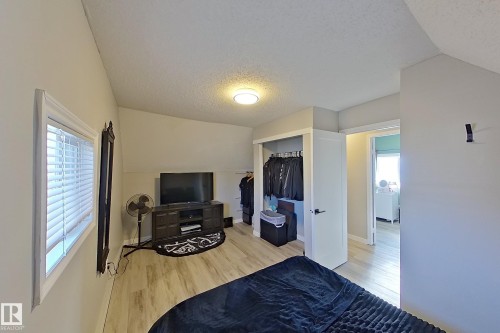 This room features light-toned flooring, a window with blinds, and a built-in closet - 9328 106A Avenue, Edmonton, AB - Indoor Photo Showing Other Room