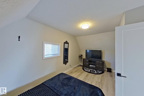 This room features light-colored walls and wood-look flooring, with a window providing natural light - 9328 106A Avenue, Edmonton, AB - Indoor
