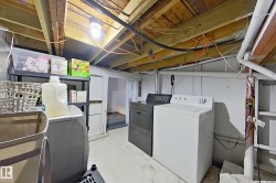 Dedicated laundry area with a white washing machine and a dark-colored dryer - 