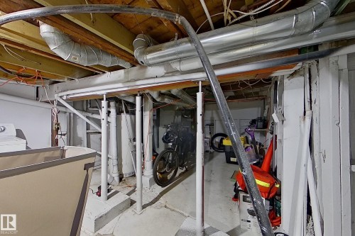 The property features an unfinished basement with exposed wooden joists, visible ductwork, and a concrete floor - 9328 106A Avenue, Edmonton, AB - Indoor Photo Showing Basement
