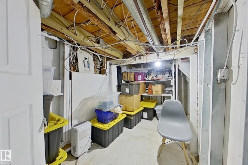 The property features a utility area with exposed ceiling joists and visible electrical wiring, offering practical access to systems - 9328 106A Avenue, Edmonton, AB - Indoor Photo Showing Basement