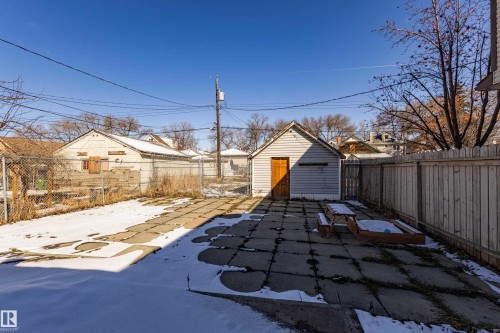 The property features a detached garage with horizontal siding and a wooden door - 9328 106A Avenue, Edmonton, AB - Outdoor