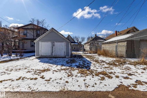 The property features a detached garage with double doors and a gabled roof - 9328 106A Avenue, Edmonton, AB - Outdoor